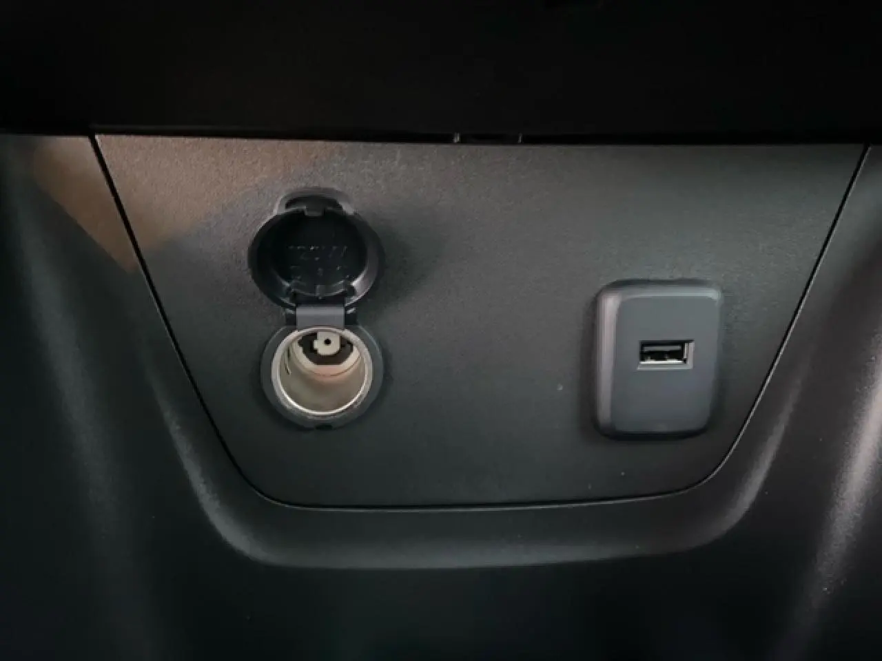 Prise allume-cigare et port USB intégrés dans la console centrale noire de l’Opel Crossland gris Magnetic.