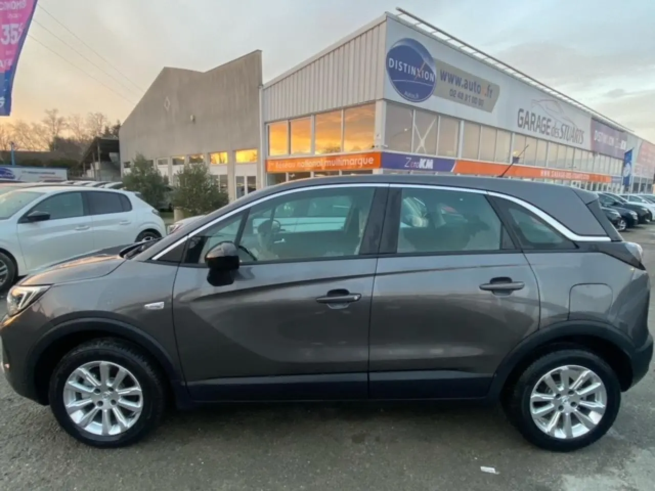 Vue de profil côté gauche d'un Opel Crossland gris magnetic 2022 avec jantes alliage 16 pouces et vitres surteintées.