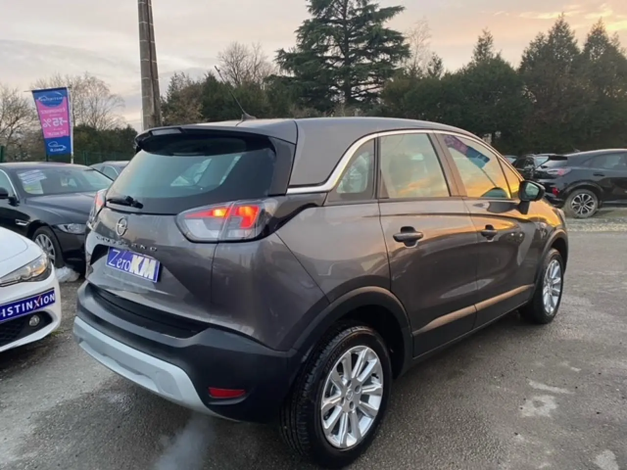 Vue 3/4 arrière droite d'un Opel Crossland gris magnetic 2022 avec jantes alliage 16'' et vitres surteintées.