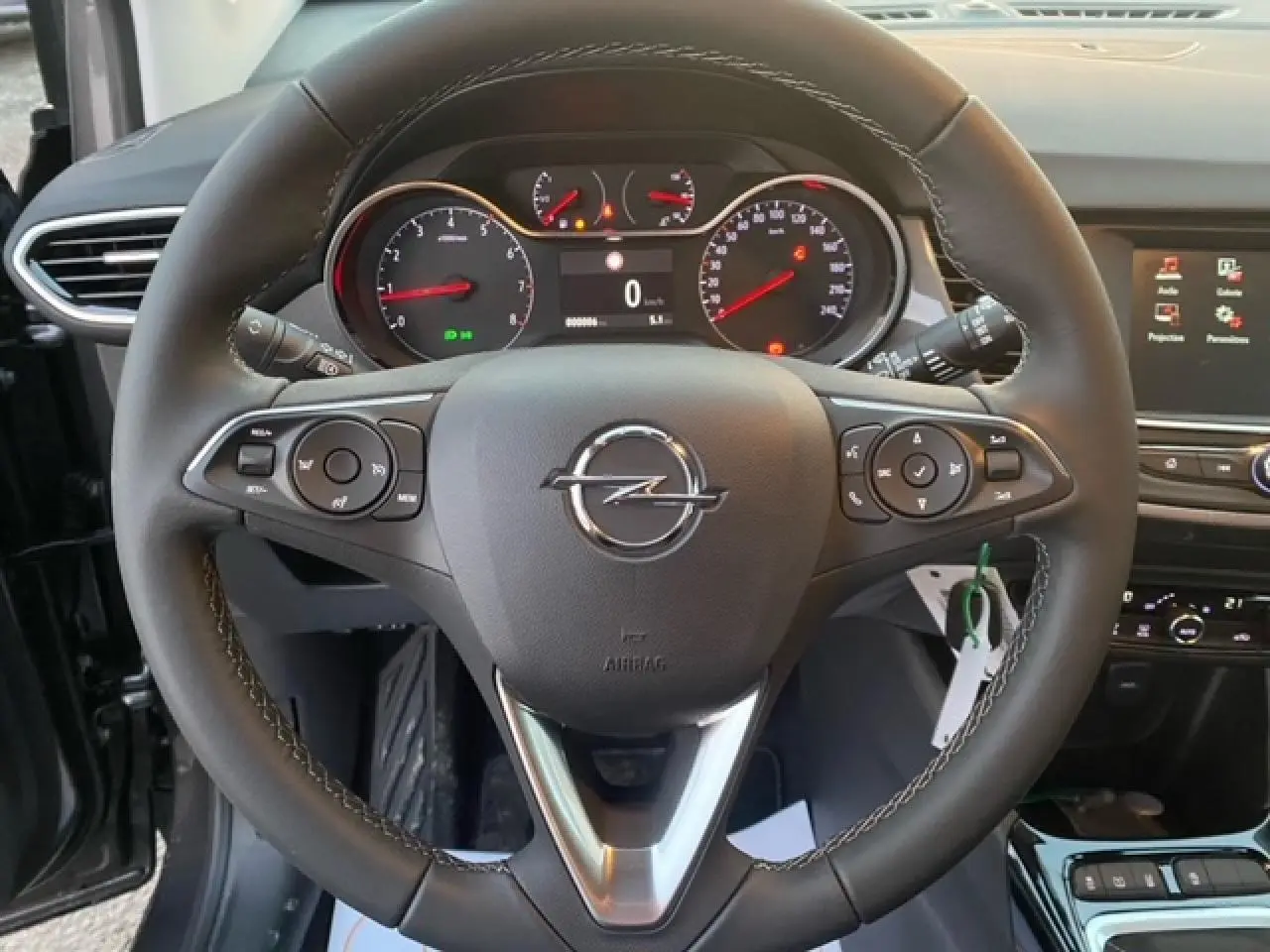 Vue rapprochée du volant noir de l’Opel Crossland 2022 avec tableau de bord et écran tactile en arrière-plan.