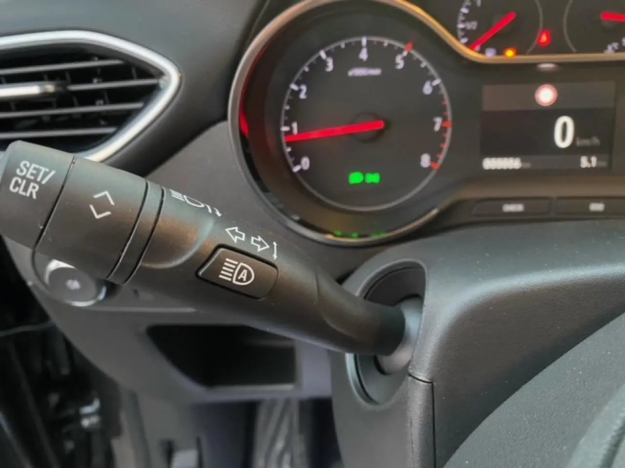 Gros plan sur le commodo gauche et le tableau de bord digital d’un Opel Crossland gris Magnetic, version 2022.