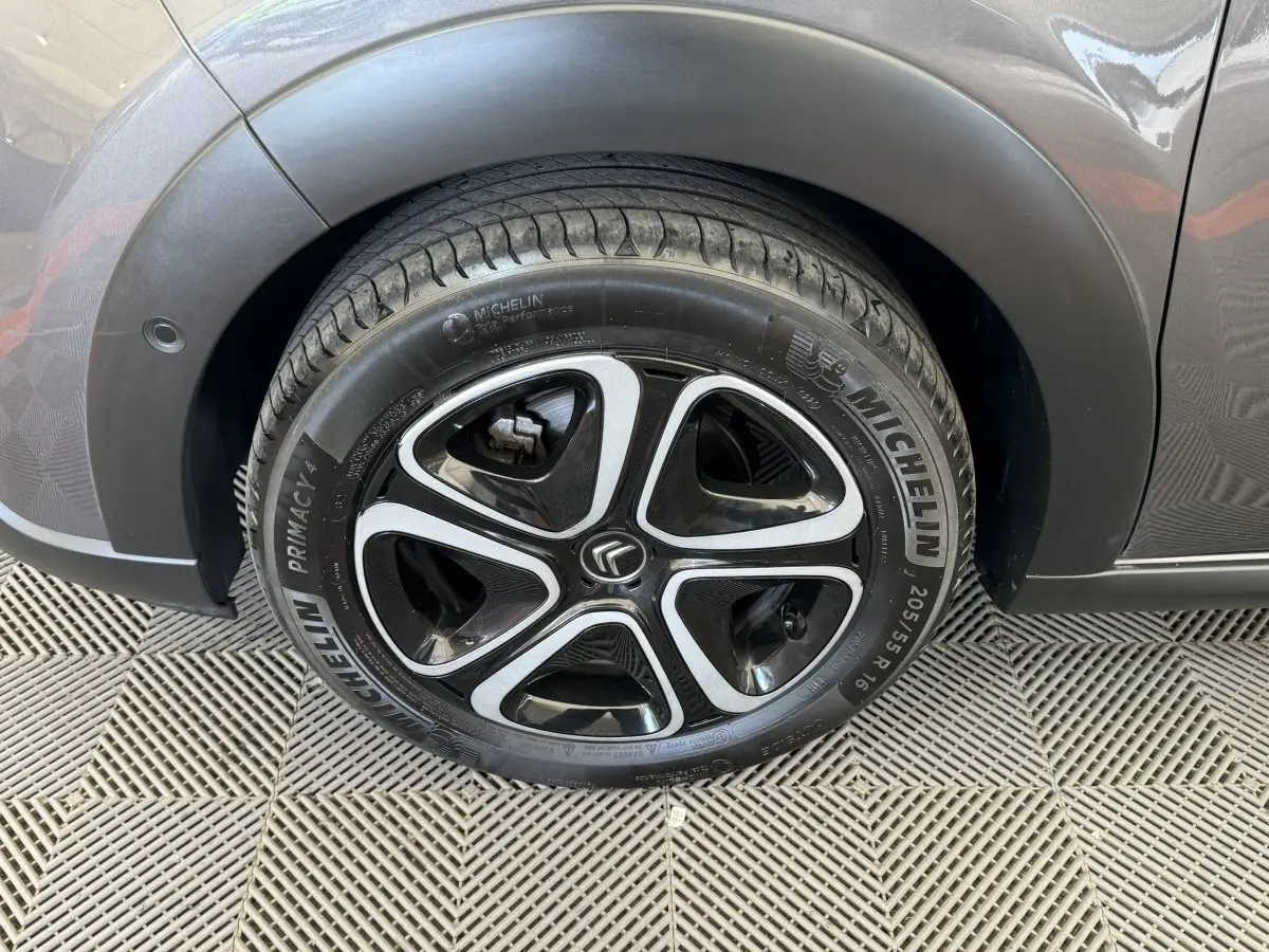 Gros plan sur la roue avant gauche gris foncé d'une Citroën C3 avec jante alliage et pneu Michelin.