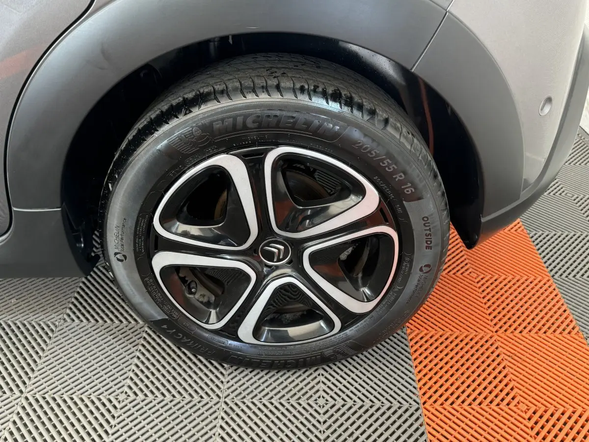 Gros plan sur la roue arrière droite gris foncé d'une Citroën C3 2020 avec jante alliage noire et argentée distinctive.