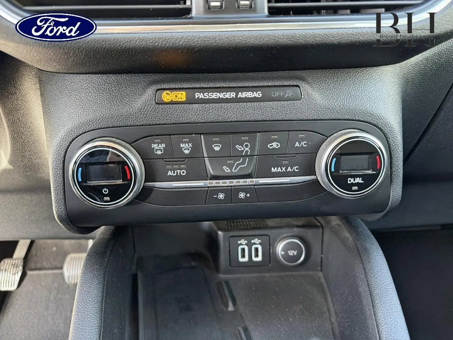 Vue rapprochée de la console centrale du Ford Kuga 2021, montrant la climatisation bi-zone et les ports USB avec prise 12V.