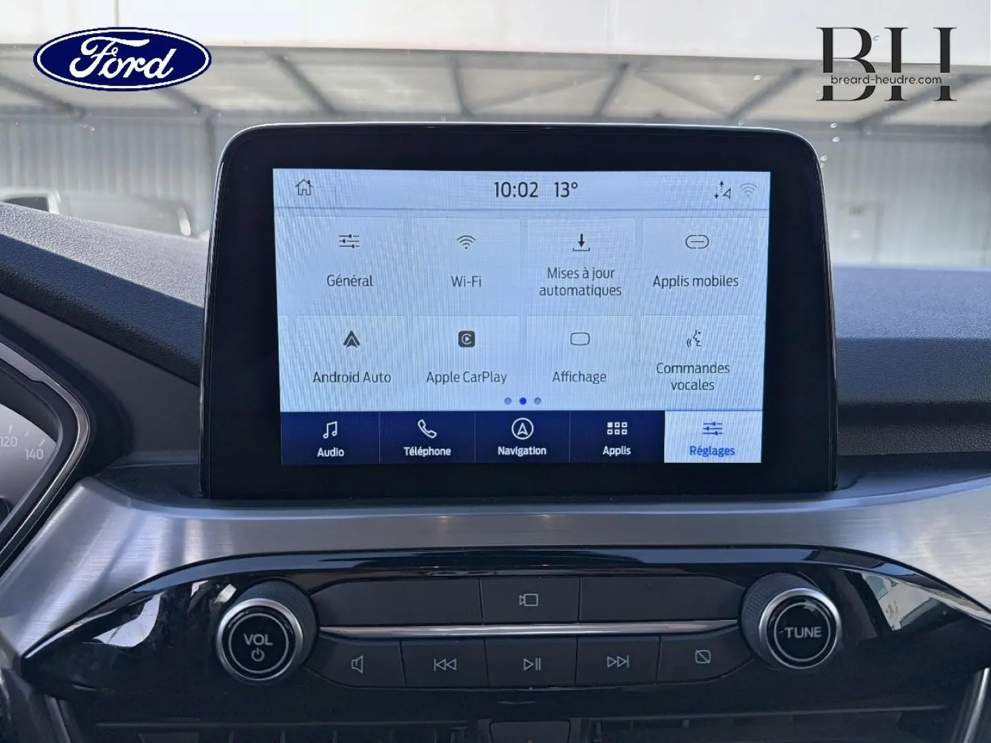 Vue rapprochée de l’écran tactile central et de la console noire brillante du Ford Kuga blanc Glacier 2021.
