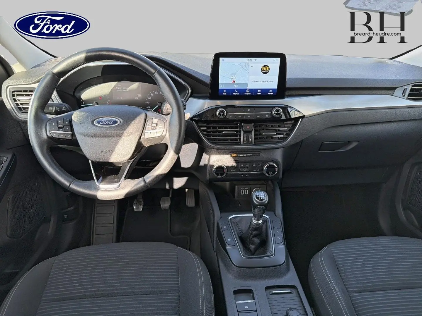 Vue intérieure frontale du Ford Kuga 1.5 EcoBlue 2021, montrant le volant cuir multifonction et la console centrale avec écran tactile.