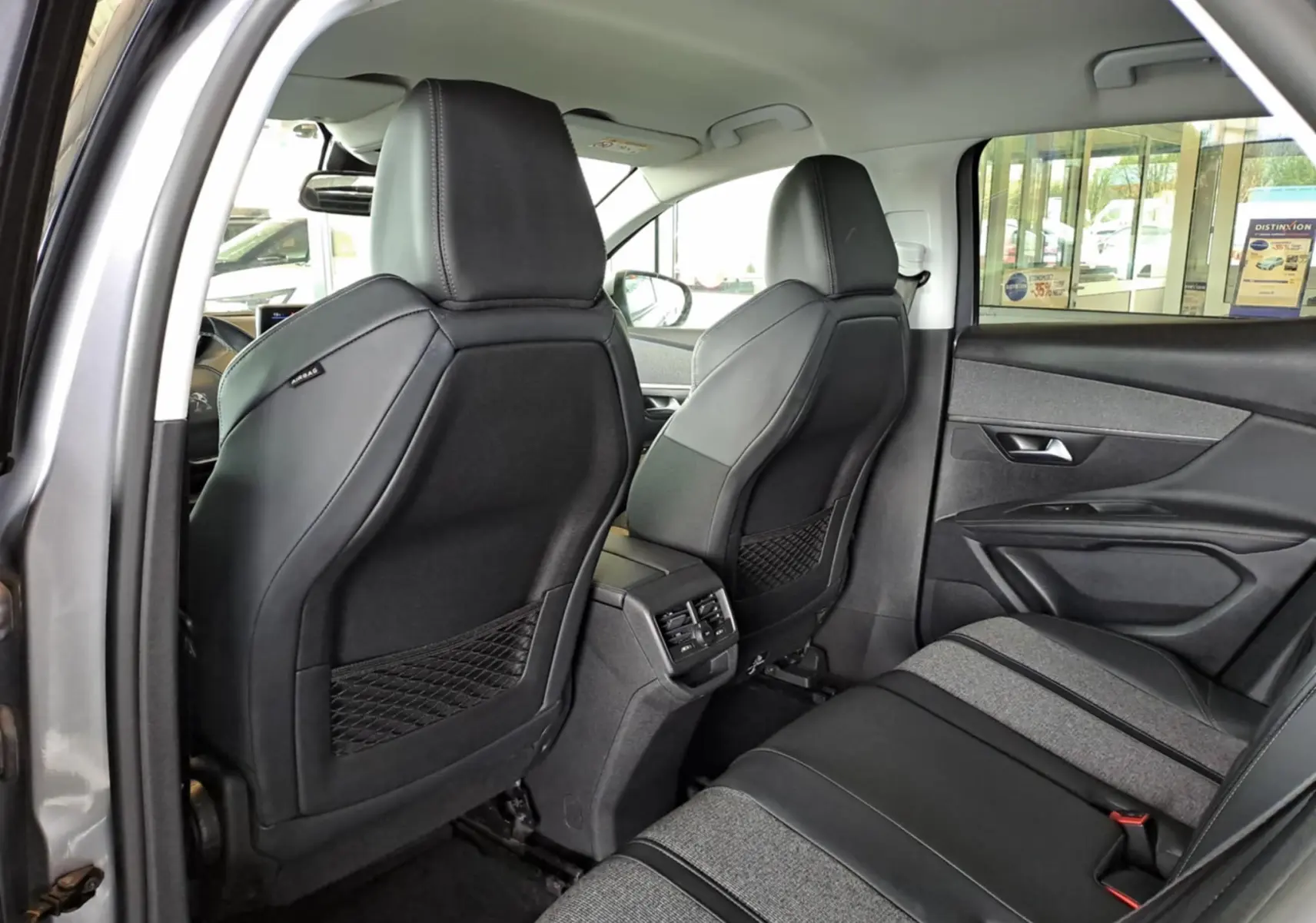 Vue intérieure arrière droite du Peugeot 3008 gris Artense, montrant les sièges en tissu et cuir noir avec détails gris.