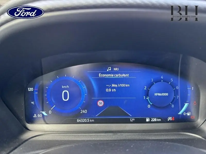 Tableau de bord numérique bleu du Ford Puma 2022 affichant vitesse, régime moteur et économie de carburant.