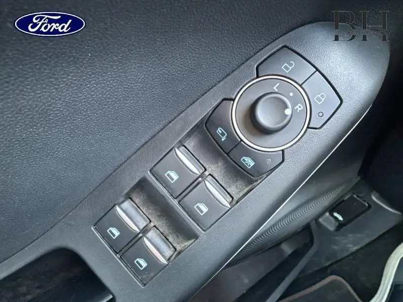 Panneau de commandes des vitres et rétroviseurs côté conducteur de la Ford Puma blanc glacier, intérieur noir.