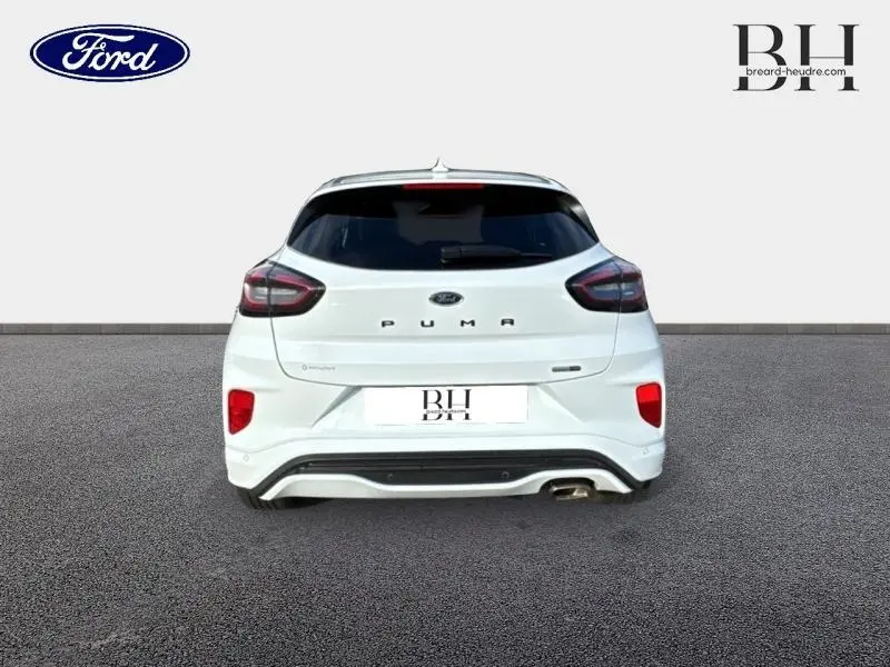 Vue arrière d'une Ford Puma blanc glacier avec hayon électrique et feux arrière LED sur fond neutre.
