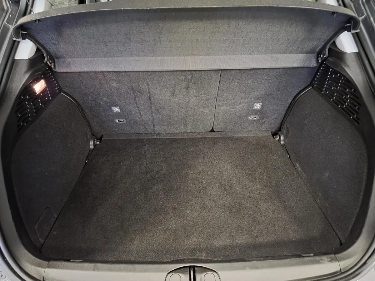 Coffre ouvert vu de dessus du Fiat 500X gris, montrant un espace de chargement propre et bien éclairé.