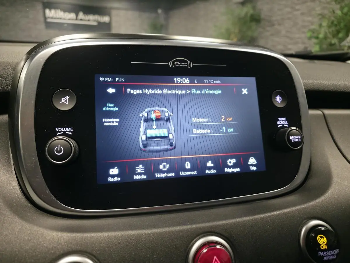 Écran tactile central affichant le flux d'énergie du système hybride dans l'habitacle du Fiat 500X gris, vue intérieure.