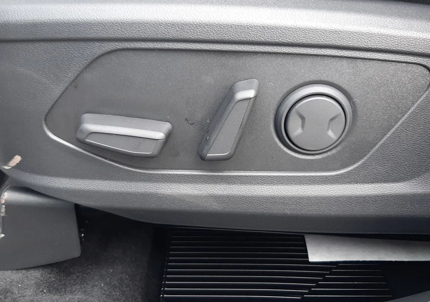Gros plan sur les commandes de réglage électrique du siège côté conducteur du Hyundai Tucson 2025 gris Ecotronic.