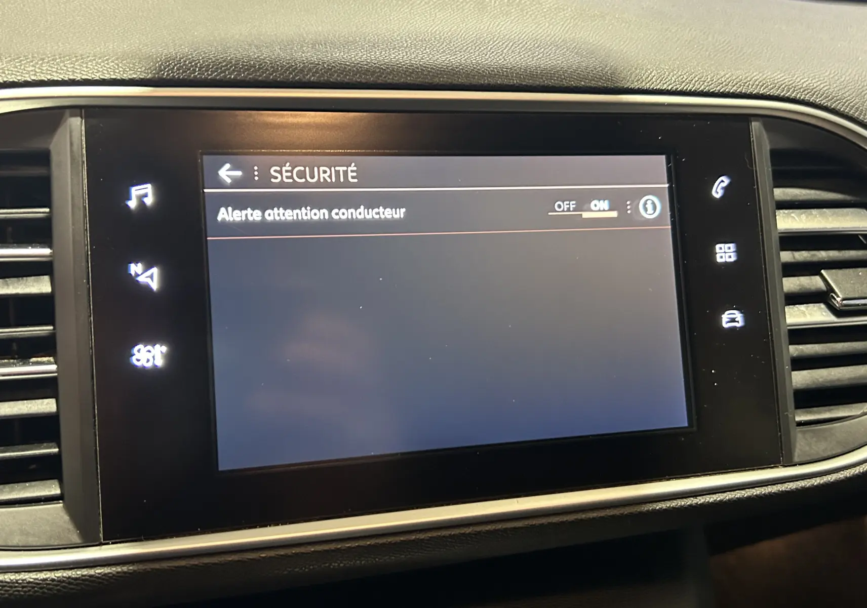 Écran tactile central de la Peugeot 308 SW noir affichant le menu sécurité avec l'alerte attention conducteur activée.