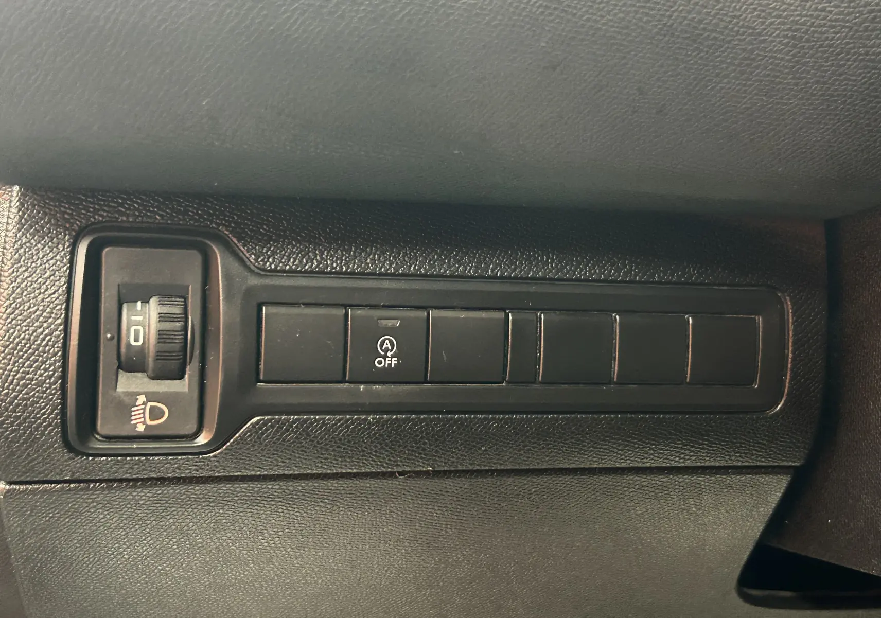 Détail de la console intérieure noire du Peugeot 308 SW 2018, montrant les boutons de réglage des phares et de désactivation du système start-stop.
