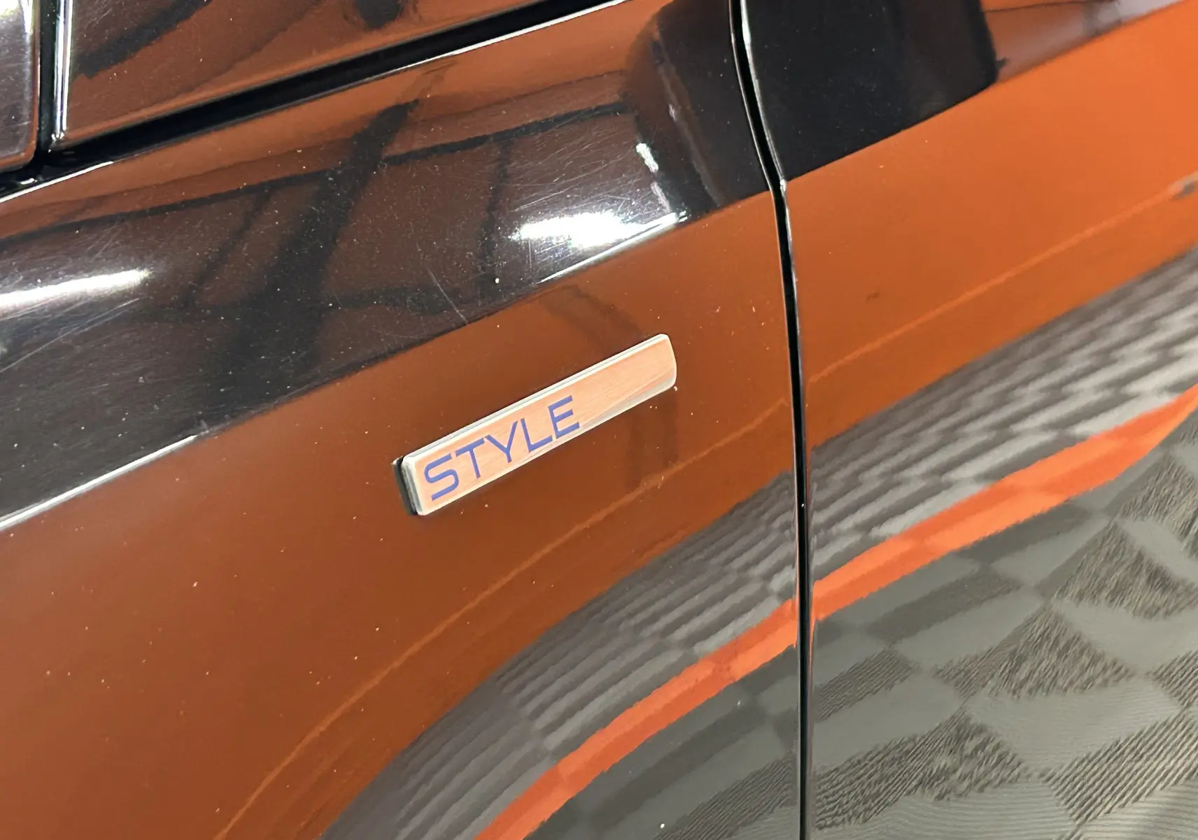 Gros plan sur l’insigne "STYLE" sur la portière noire brillante d’une Peugeot 308 SW.
