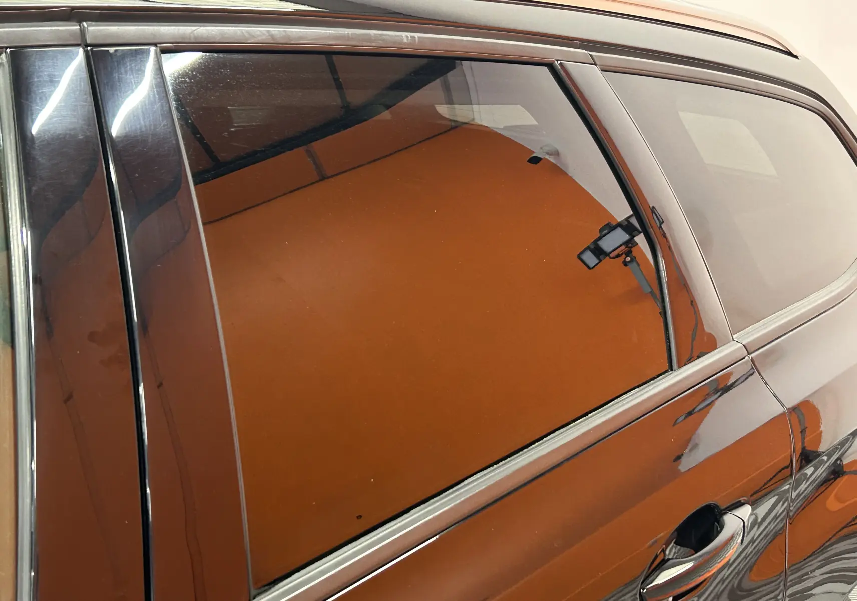 Vue latérale droite rapprochée d’une Peugeot 308 SW noire, mettant en valeur la vitre arrière teintée et la poignée de porte.