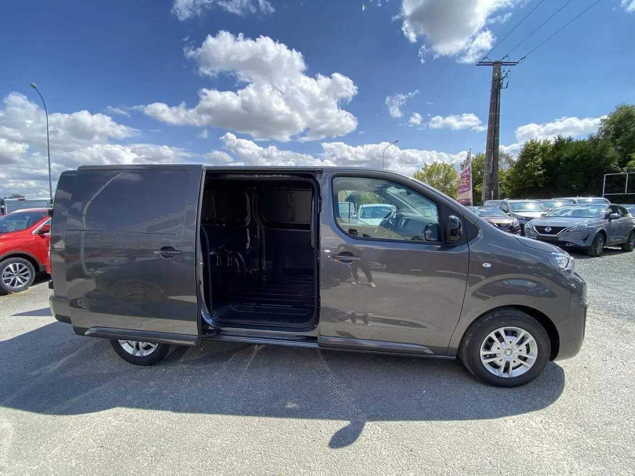 Peugeot Expert Fourgon gris platinium vu de profil gauche avec porte latérale coulissante ouverte montrant l'intérieur vide.