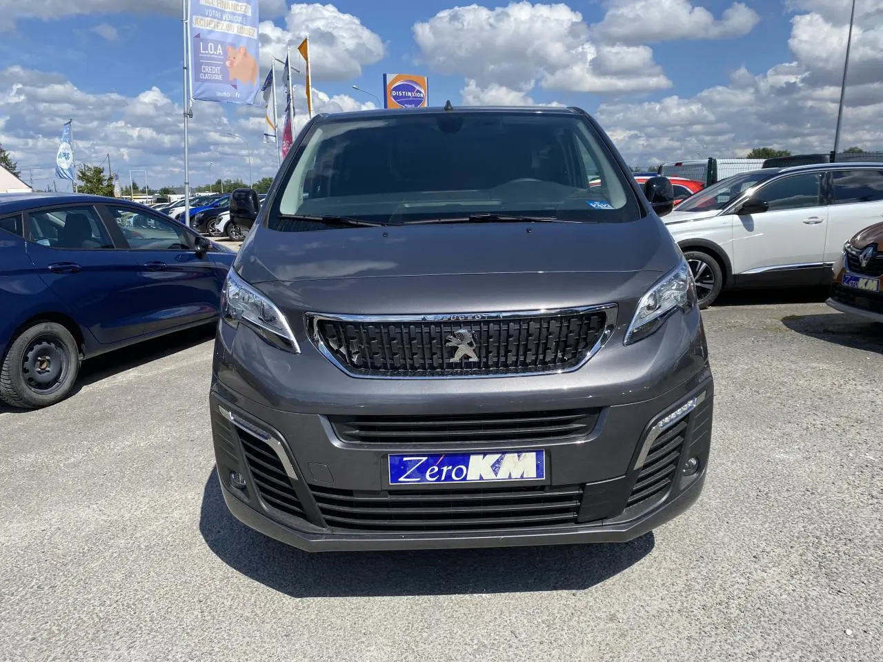 Vue avant d'un Peugeot Expert Fourgon gris platinium avec calandre noire et plaque d'immatriculation Zero KM visible.