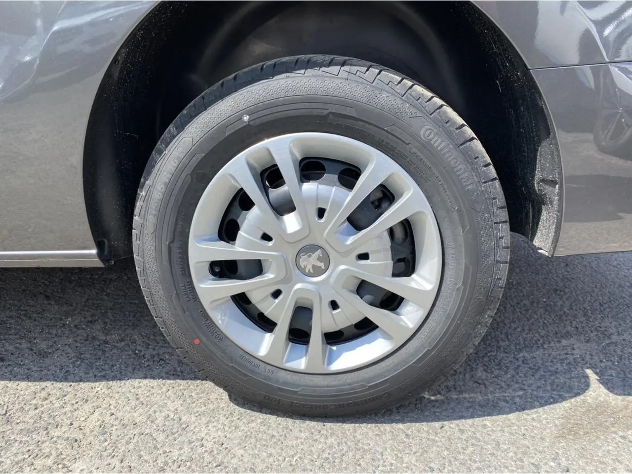 Gros plan sur la roue avant droite du Peugeot Expert Fourgon gris platinium avec jante en alliage et pneu Continental.