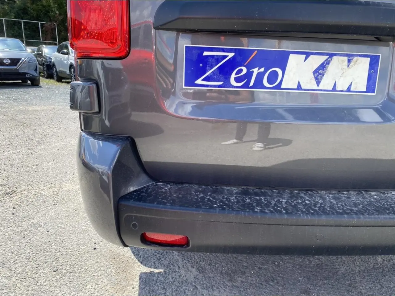 Vue rapprochée de l'arrière droit du Peugeot Expert Fourgon gris platinium avec plaque Zéro KM visible.
