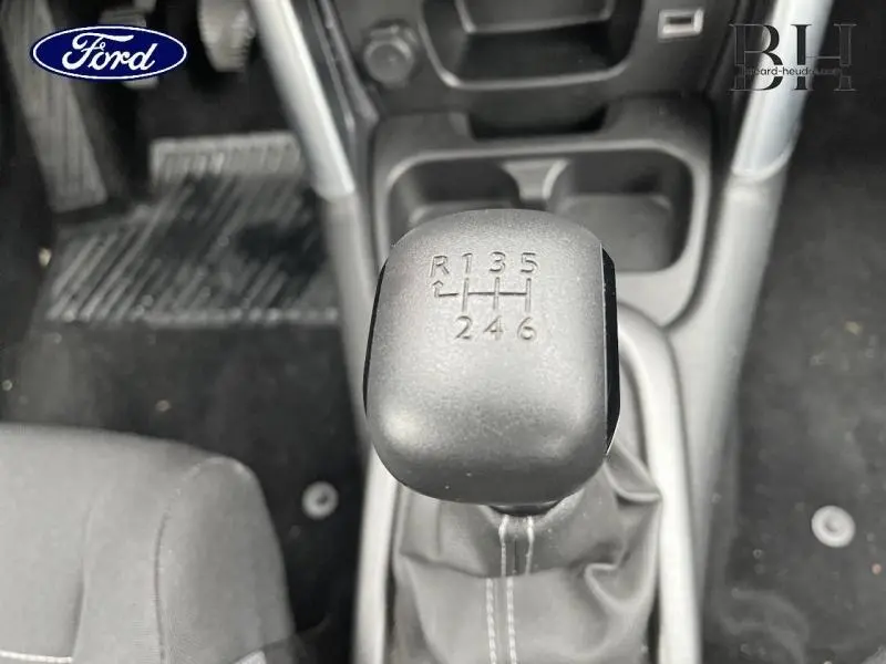 Gros plan sur le levier de vitesses manuel noir dans l'habitacle d'un Citroën C3 Aircross blanc, vue de dessus.