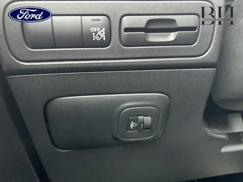 Détail du tableau de bord noir avec commande de réglage des phares sur Citroën C3 Aircross blanc vue intérieure.