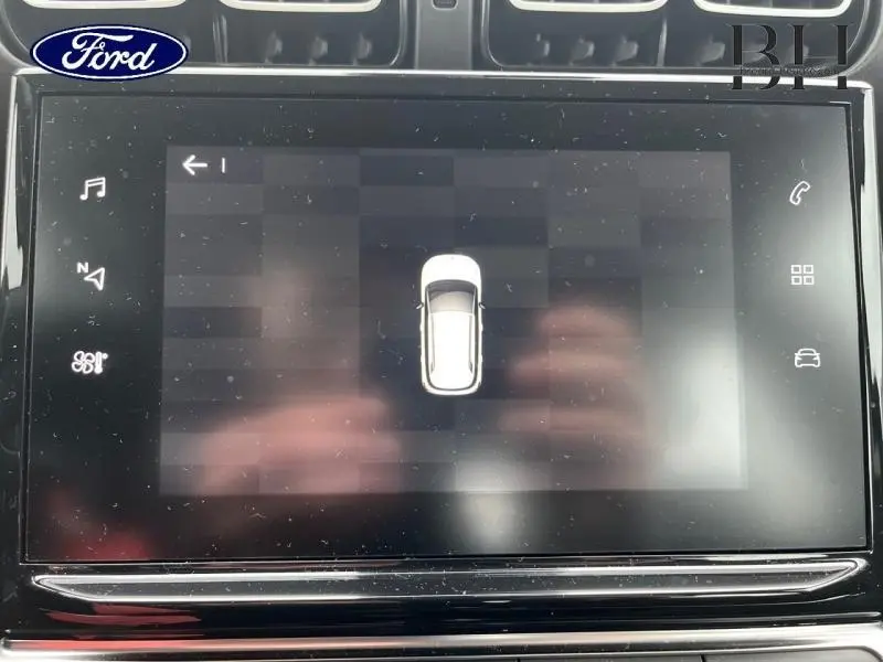 Écran tactile du système multimédia affichant une vue de dessus du véhicule blanc Natural White.