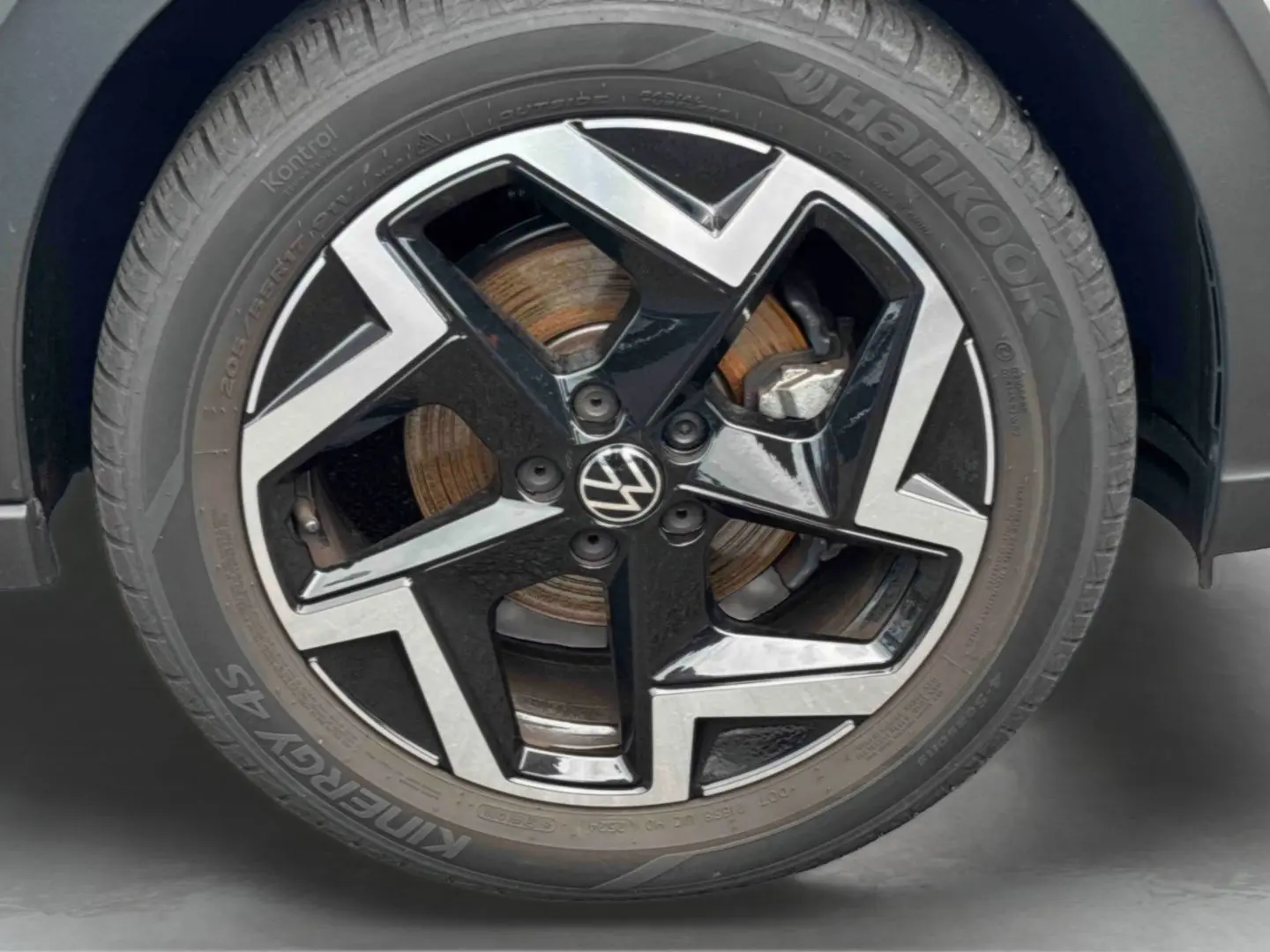 Gros plan sur la jante alliage noir et argentée de Volkswagen Taigo avec logo VW au centre et pneu Hankook.