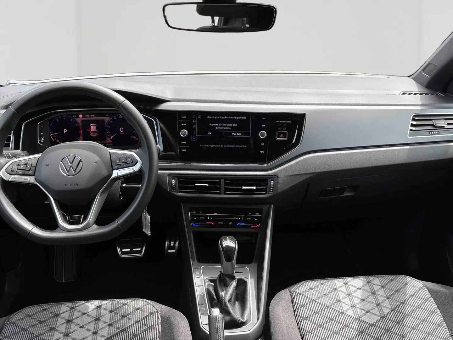 Vue intérieure avant du Volkswagen Taigo blanc 2025, volant multifonction et écran tactile central visible.
