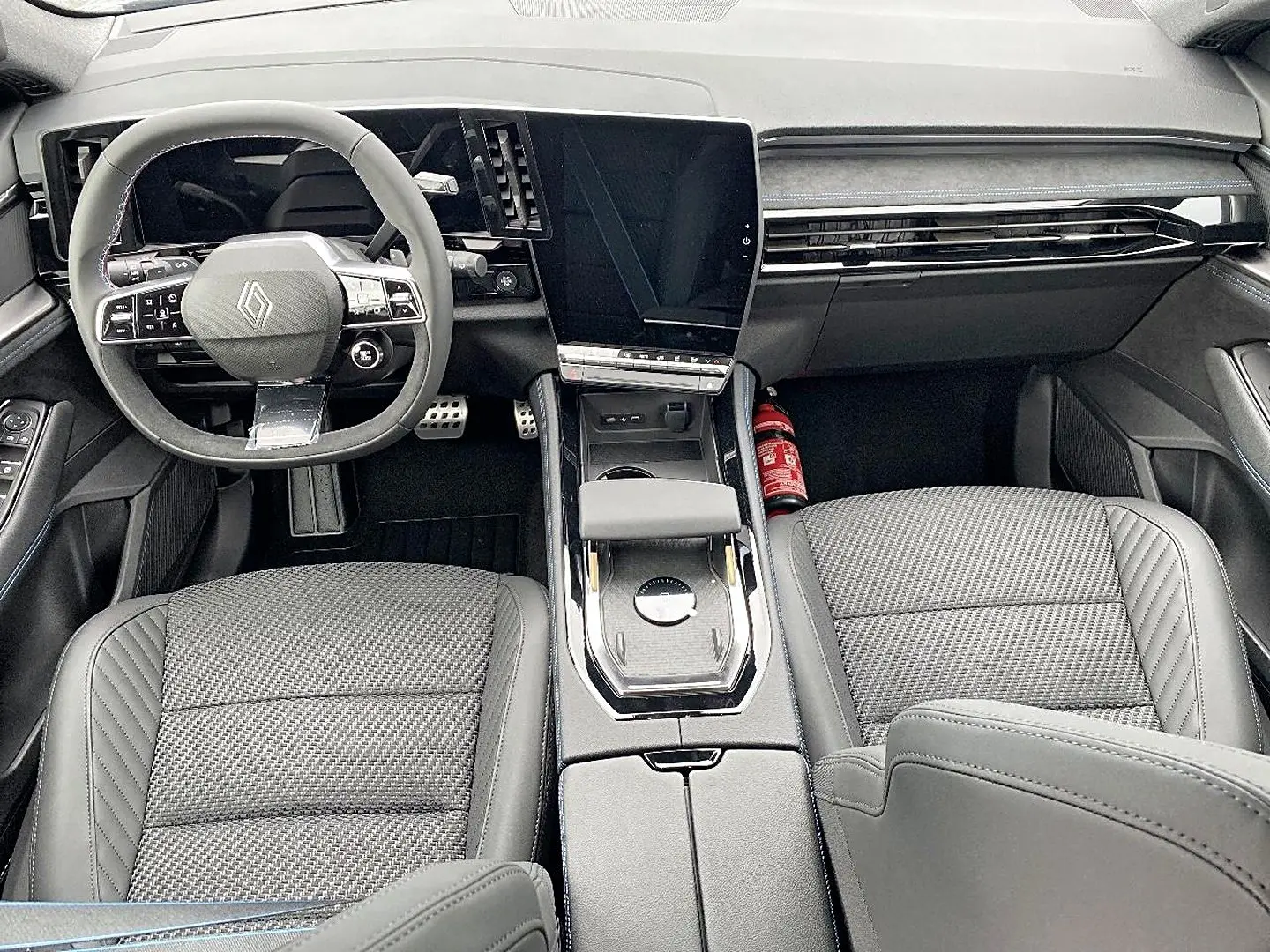 Vue intérieure avant du Renault Austral gris schiste, avec volant multifonction et grand écran tactile central.