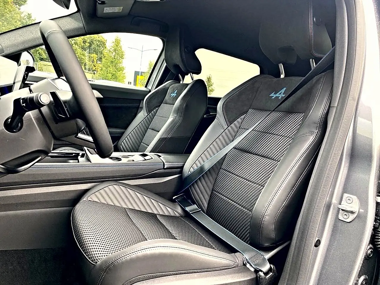 Vue intérieure côté passager avant du Renault Austral gris schiste, sièges sport avec logo esprit alpine brodé bleu.