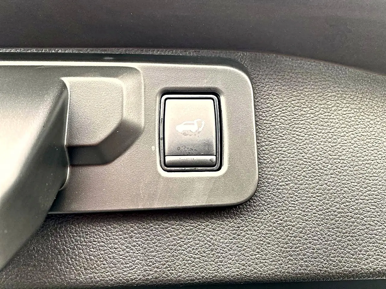 Bouton d'ouverture électrique du coffre sur panneau intérieur noir du Renault Austral gris schiste 2026.