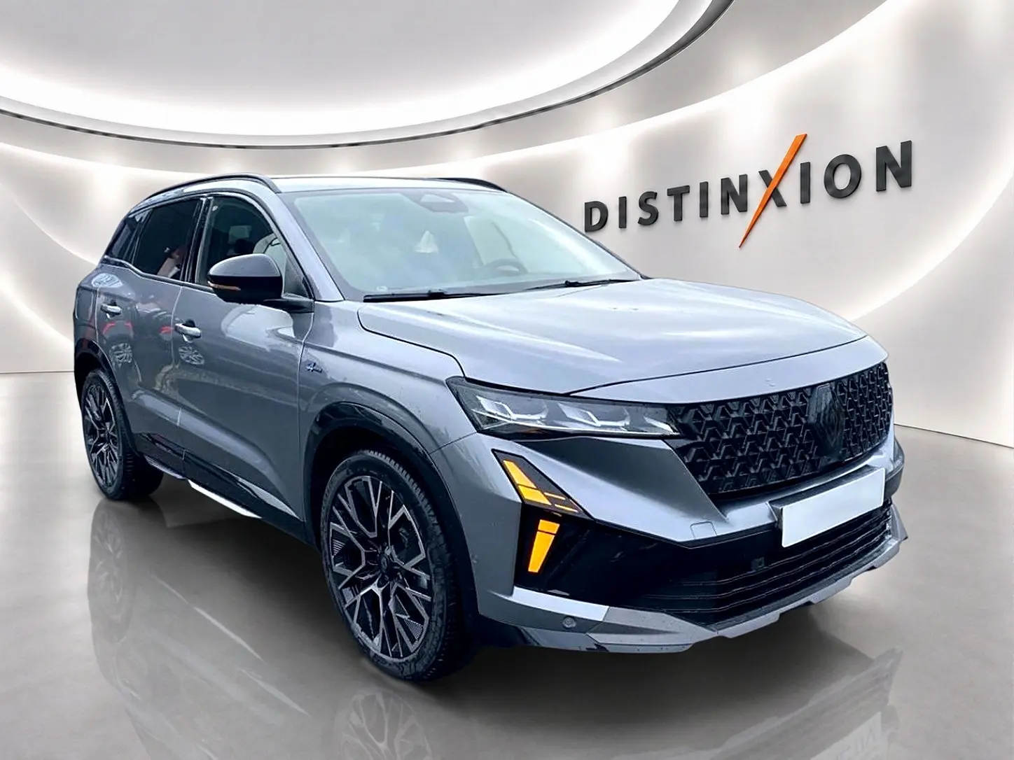Renault Austral gris schiste en 3/4 avant droit, avec calandre noire et feux LED distinctifs allumés.