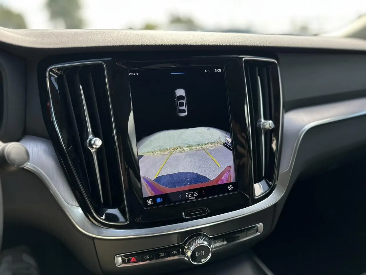 Écran tactile central affichant la caméra de recul du Volvo S60 rouge Fusion, intérieur moderne avec aérateurs noirs.