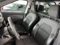 Intérieur du Renault Express Van 2021, vue côté conducteur, sièges en tissu noir et cloison vitrée séparant l'habitacle.