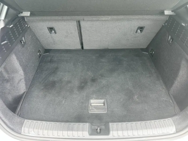 Coffre spacieux vu de face de l'Audi A3 Sportback 30 TFSI hybride 2024, revêtement tissu noir uniforme.