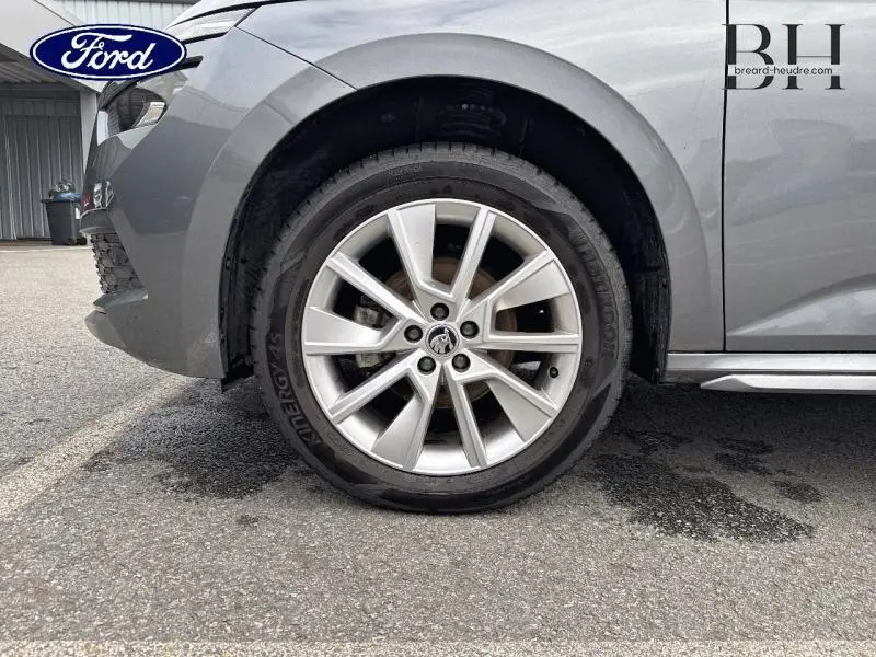 Gros plan sur la roue avant gauche d'un Skoda Kamiq gris graphite métallisé avec jante alu à dix branches.