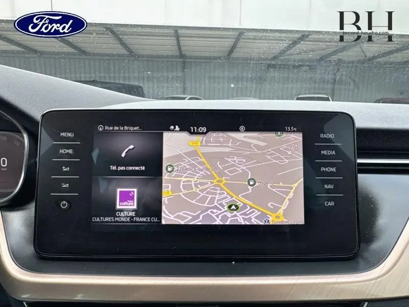 Écran tactile central du tableau de bord du Skoda Kamiq gris graphite, affichant la navigation GPS en intérieur.
