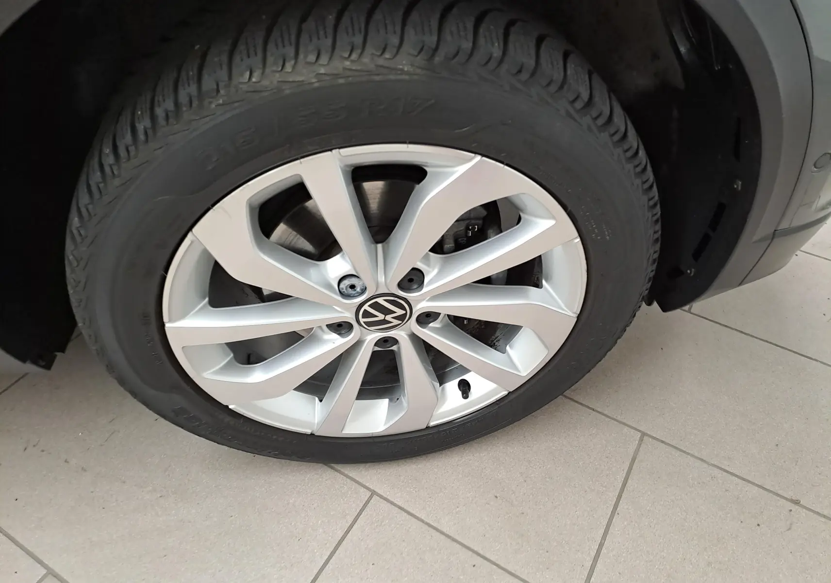 Gros plan sur la jante alliage 17'' Johannesburg d'un Volkswagen T-Roc gris Indium, mettant en valeur le logo VW central.