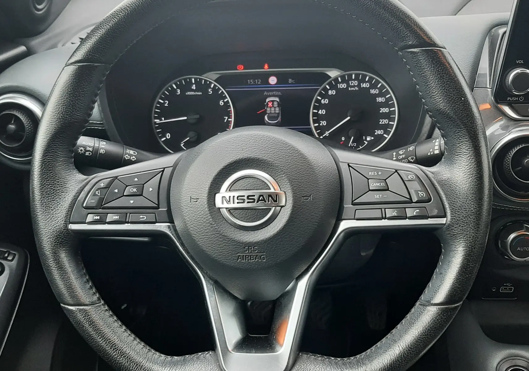 Vue rapprochée du volant noir de la Nissan Juke 2020 avec tableau de bord et commandes visibles.
