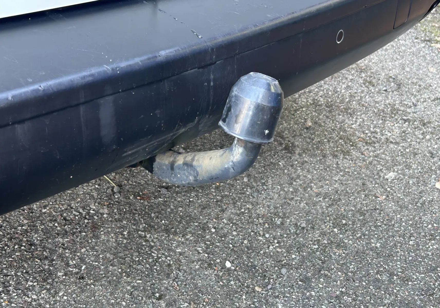 Gros plan sur l'attelage noir fixé au pare-chocs arrière du fourgon blanc Citroën Jumpy 2017.