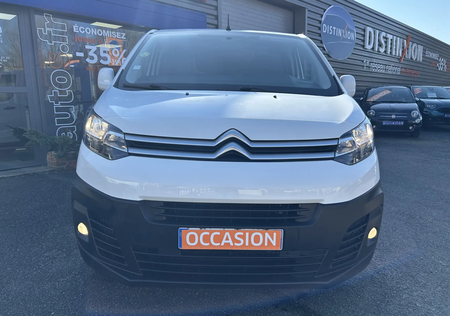 Vue de face d'un Citroën Jumpy blanc avec pare-chocs noir et plaque "OCCASION" en orange visible.