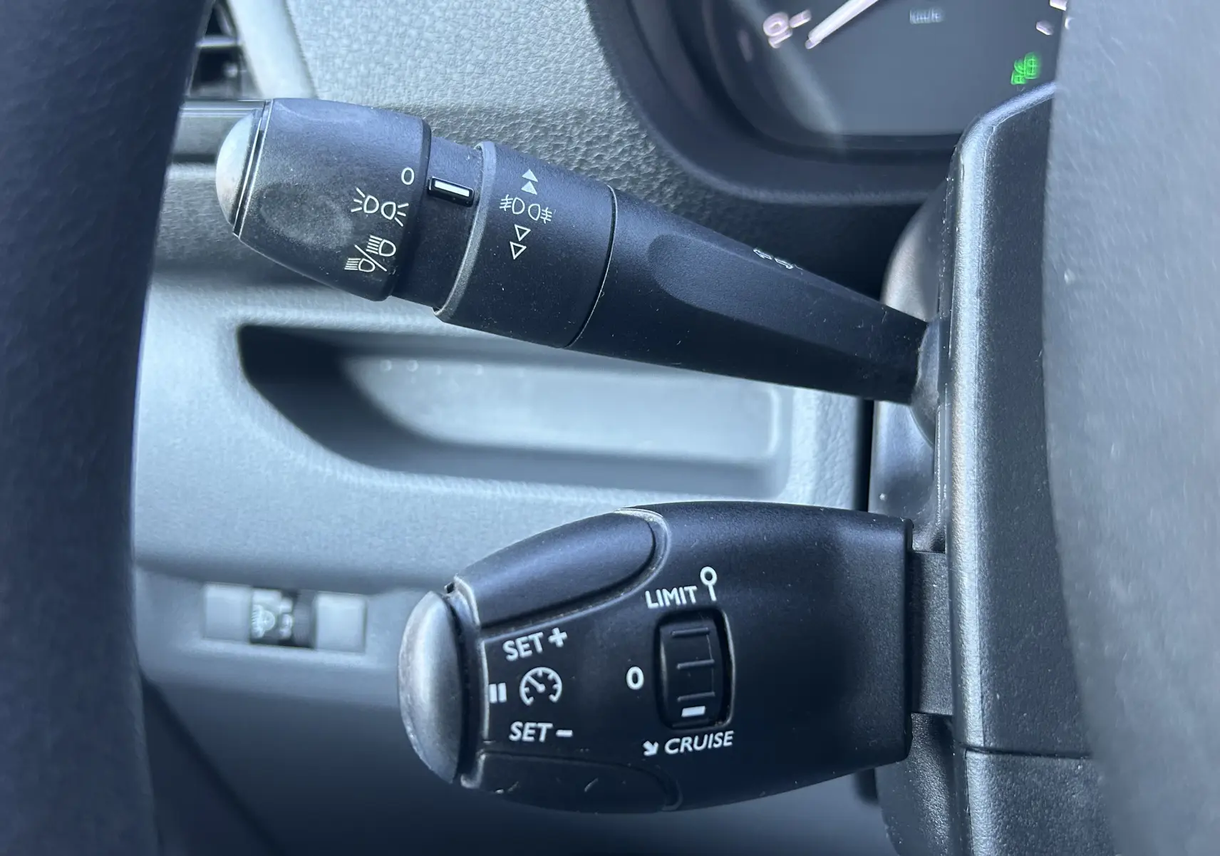 Gros plan sur les commandes de régulateur et feux au volant d’un Citroën Jumpy blanc, version Fourgon M 2017.