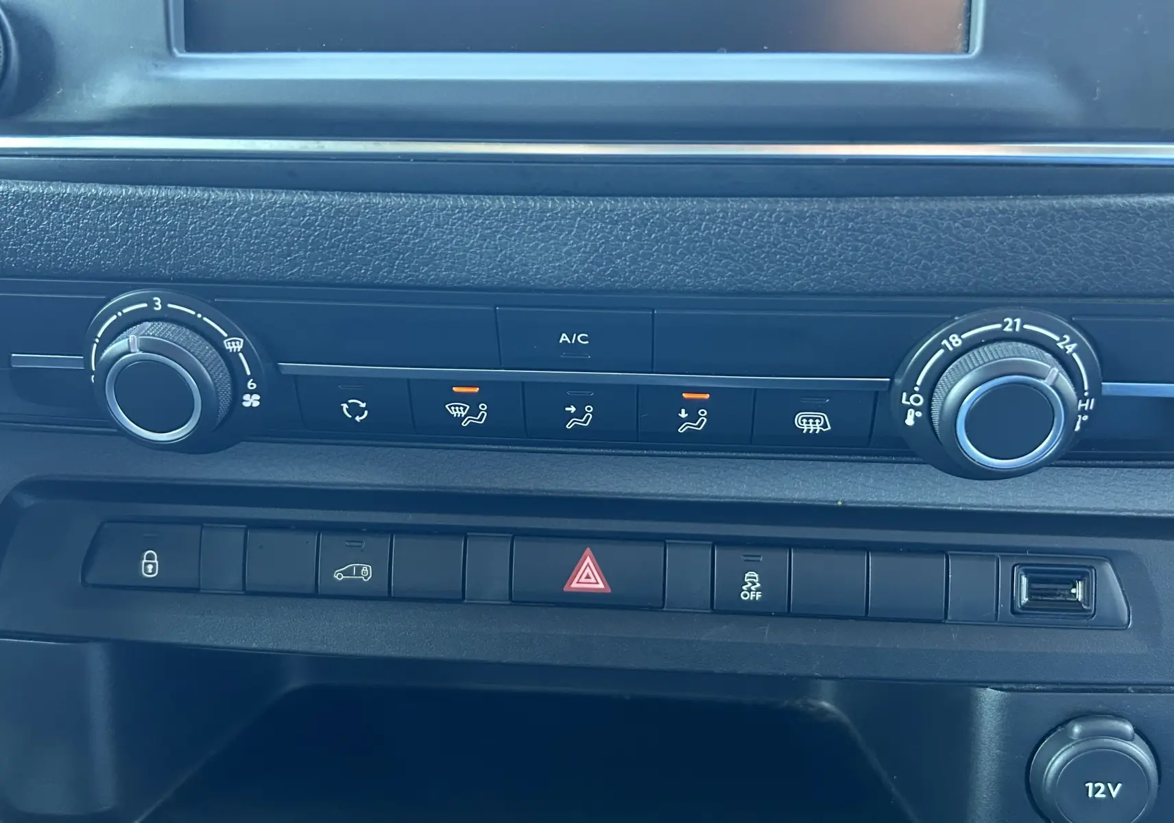 Gros plan sur la console centrale du Citroën Jumpy blanc, montrant les commandes de climatisation et les boutons de fonction.