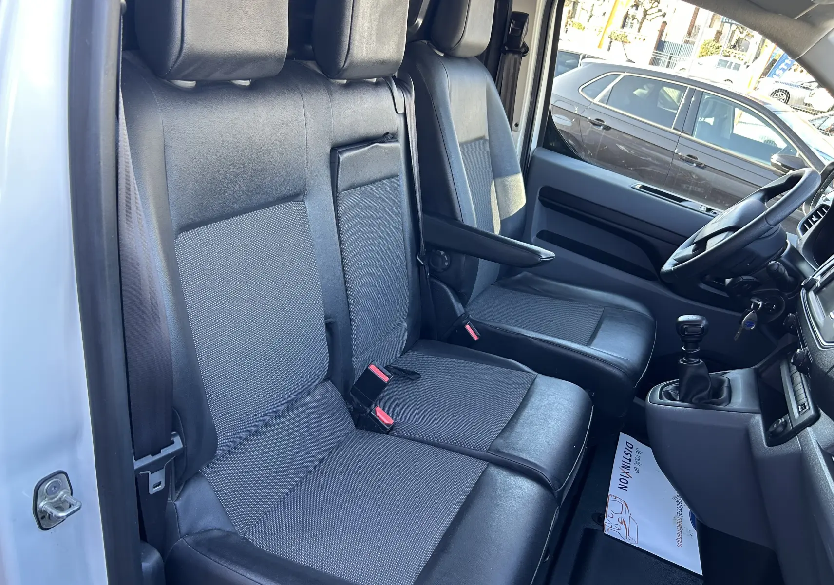 Vue intérieure côté conducteur du Citroën Jumpy blanc de 2017, montrant les sièges avant en tissu et cuir avec levier de vitesse manuel.