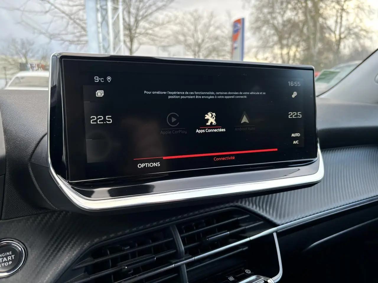 Écran tactile central du Peugeot 2008 2021 affichant la connectivité Apple CarPlay, entouré d'un tableau de bord noir texturé.