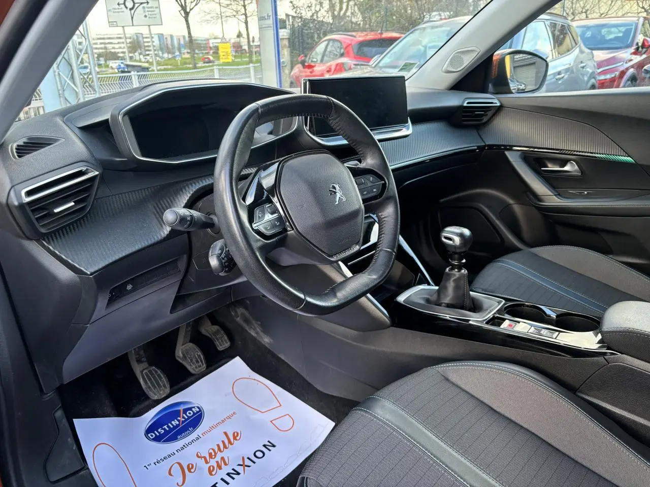 Intérieur de la Peugeot 2008 2021, vue côté conducteur, volant compact cuir et levier de vitesse manuel visibles.
