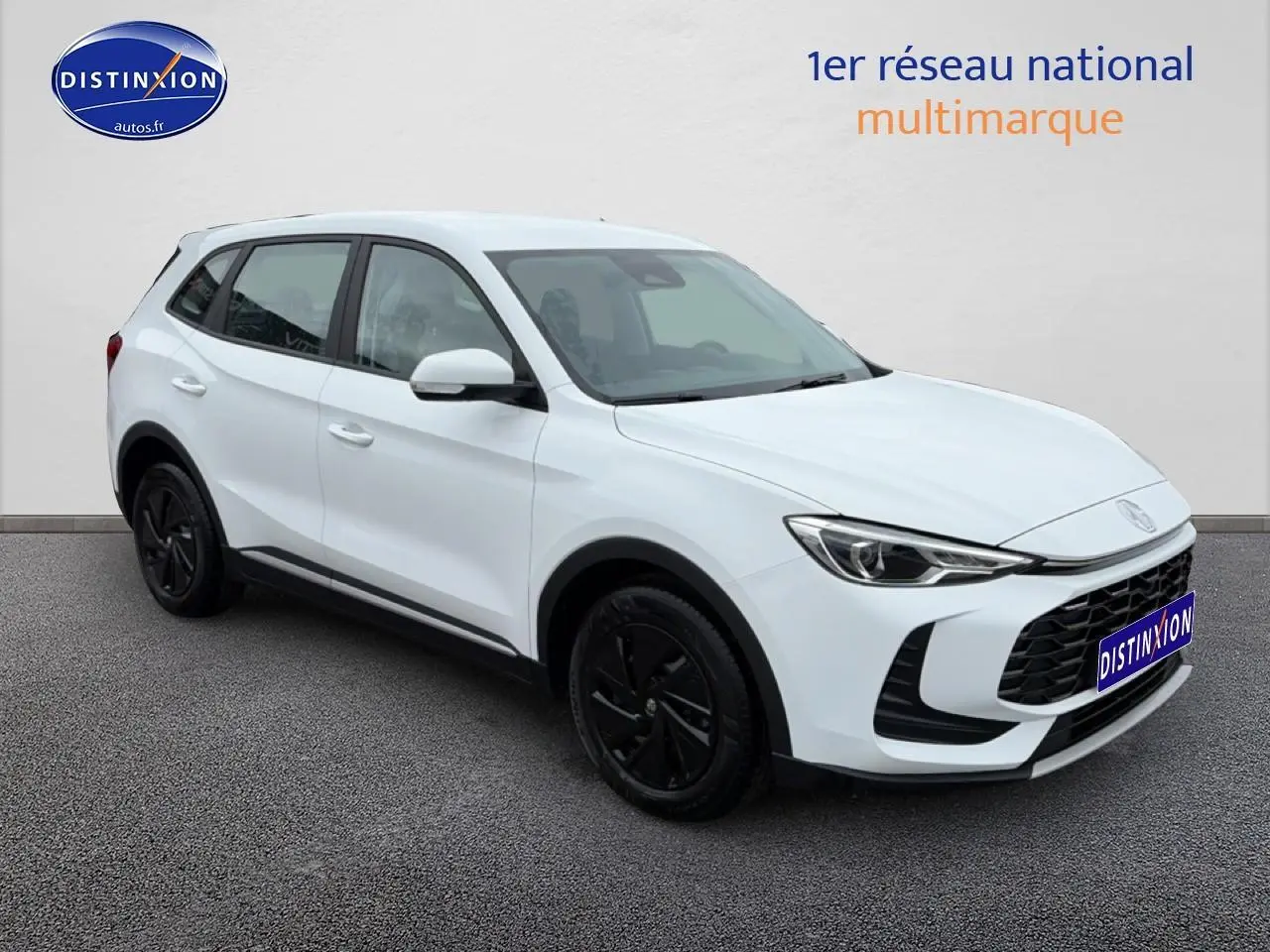 MG ZS Hybrid blanc en 3/4 avant droit, avec jantes noires et calandre imposante noire.
