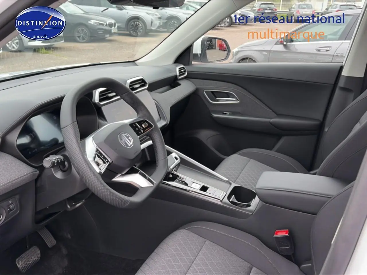 Vue intérieure côté conducteur du MG ZS Hybrid 197 blanc, avec volant multifonction et console centrale moderne.